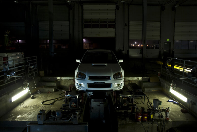 White car on lift in garage