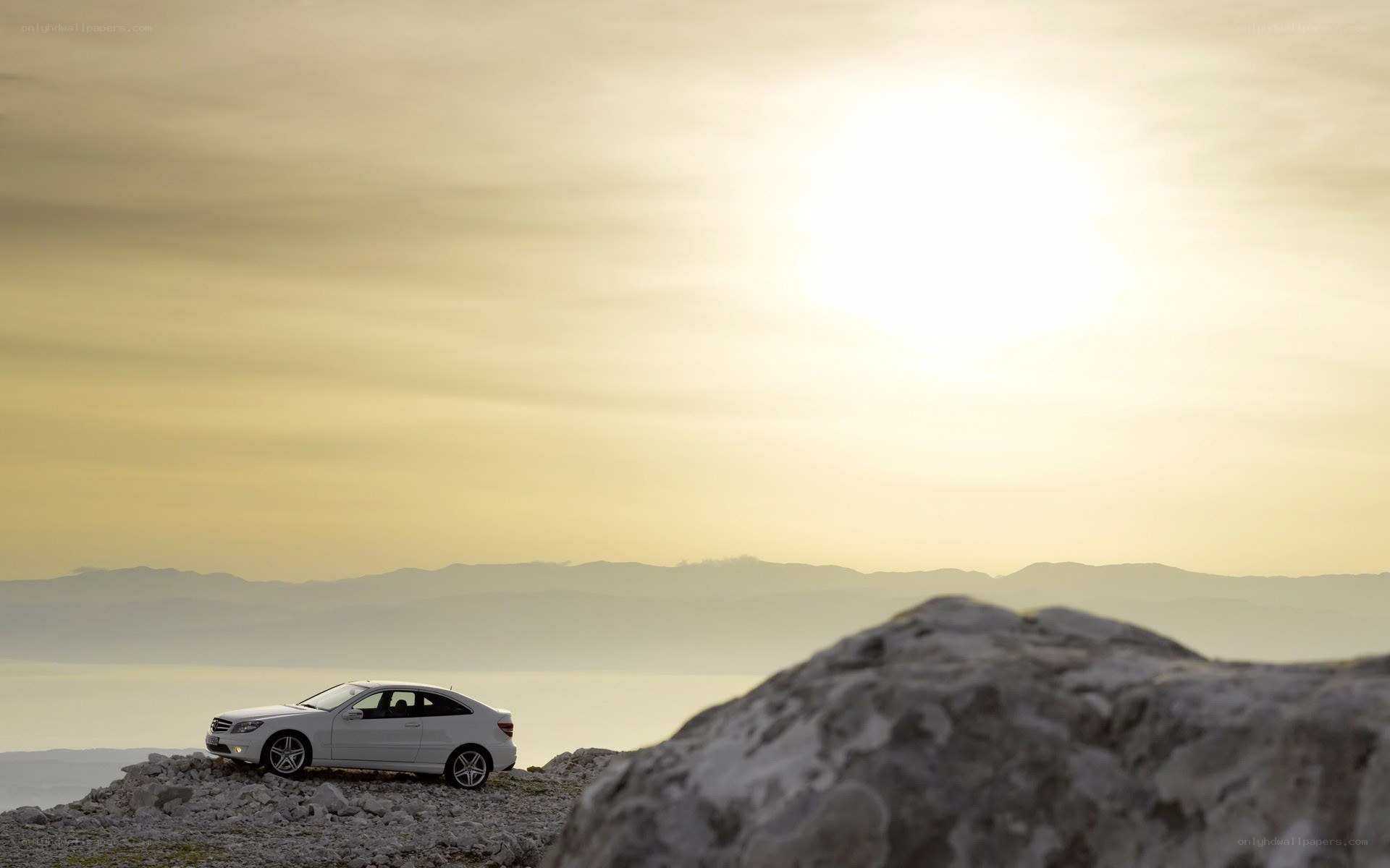 White car on rocky hillside
