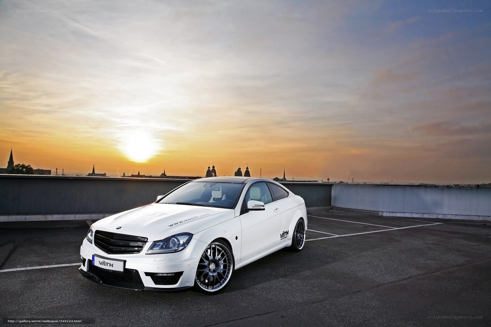 White car on rooftop at sunset