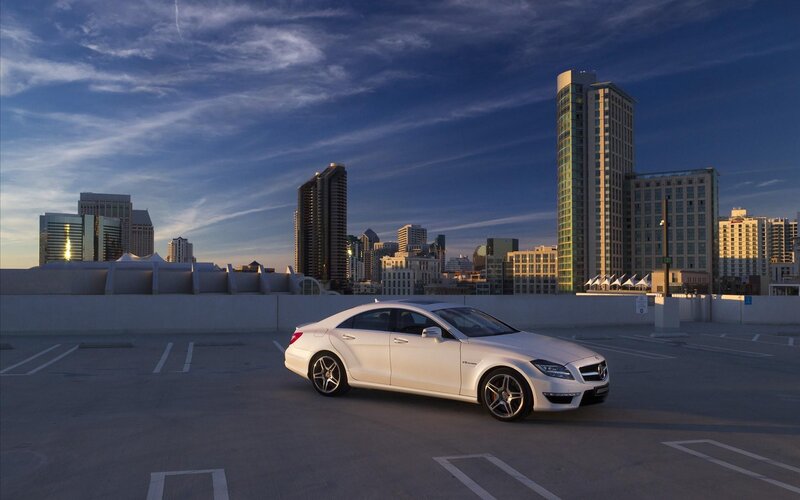 White car on rooftop with city skyline