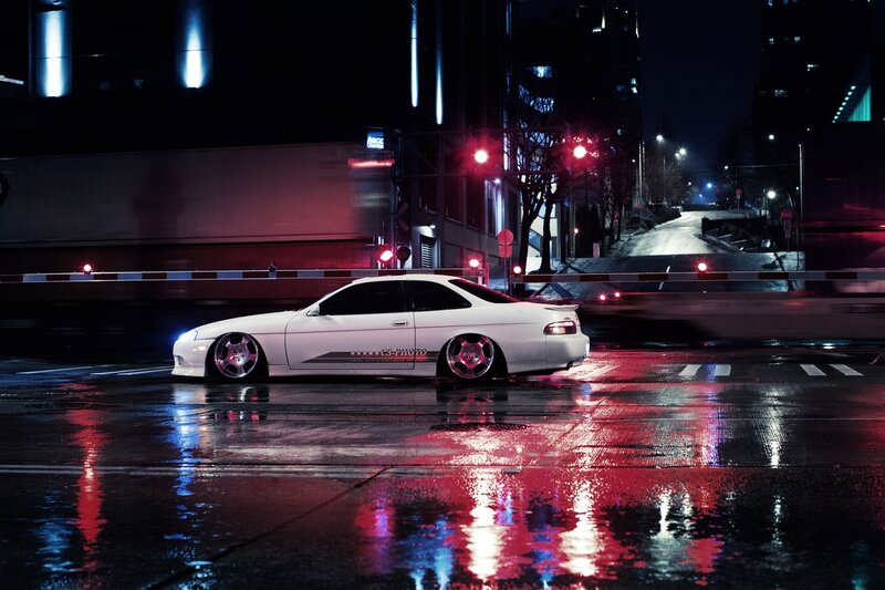 White car on wet city street