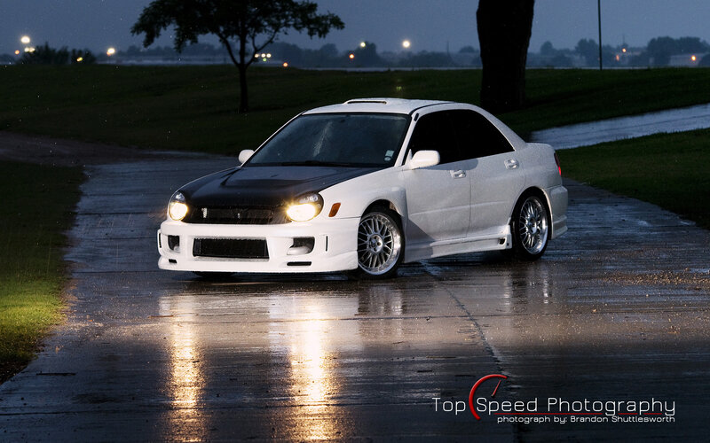 white car on wet road at night