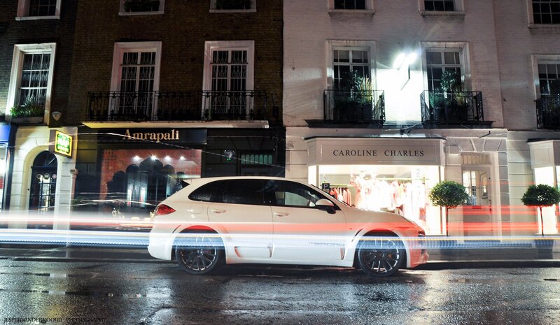 White car on wet street at night
