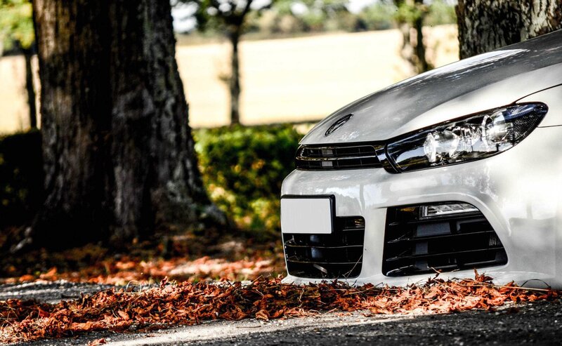 White car parked on autumn road