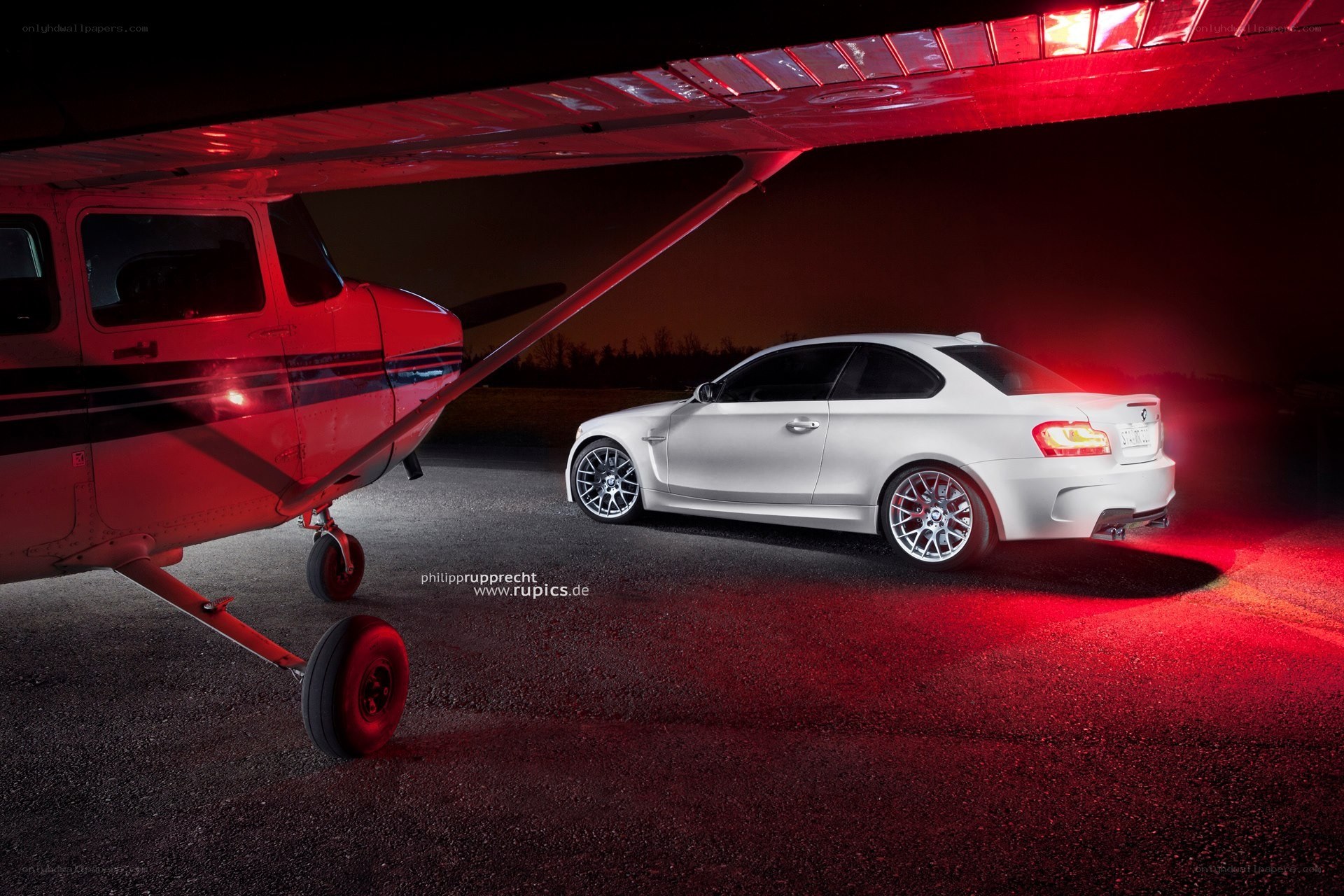 White car under red-lit plane