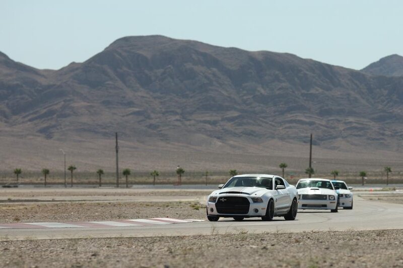 White cars on a desert racetrack