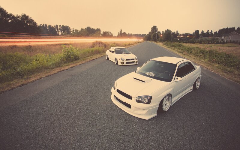 White cars on a road at dusk