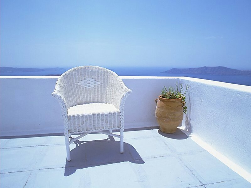 White chair on a balcony overlooking the sea
