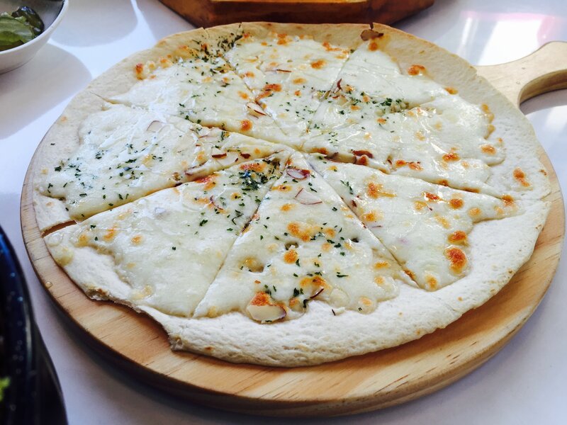 White cheese pizza on wood board