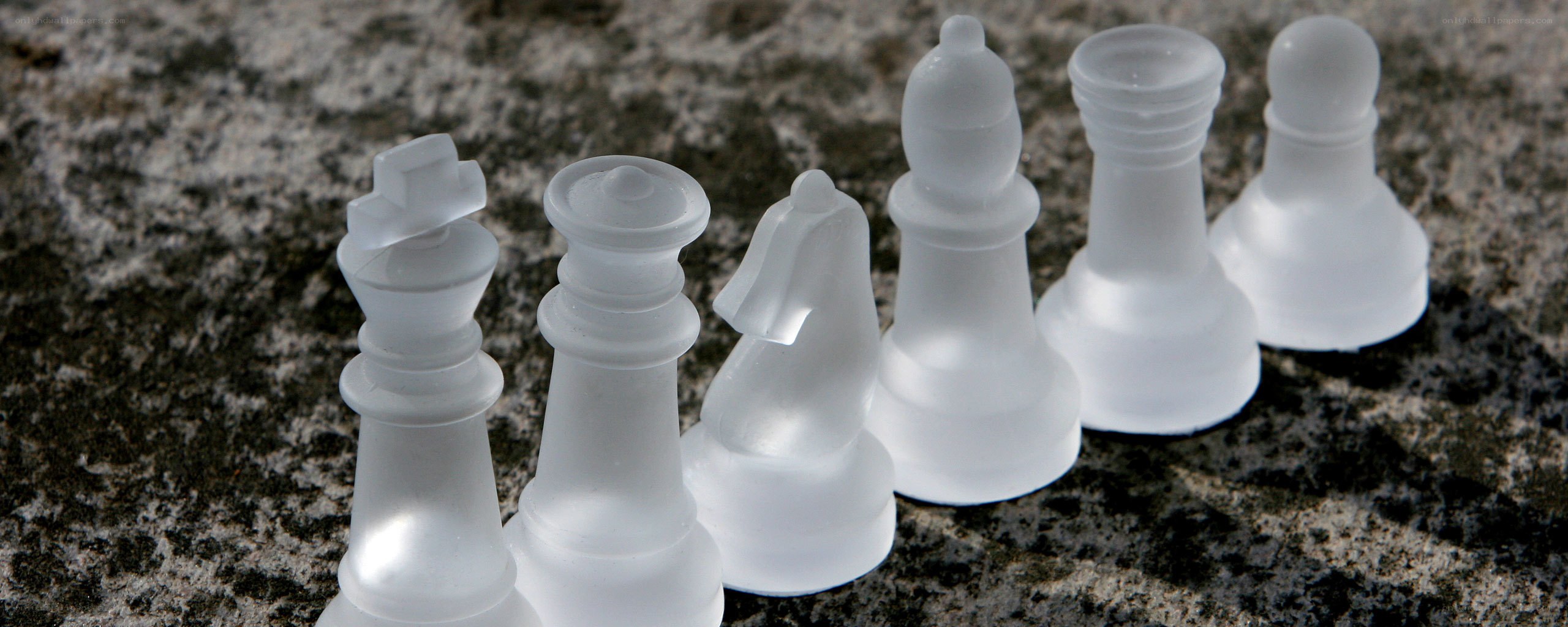 white chess pieces on stone