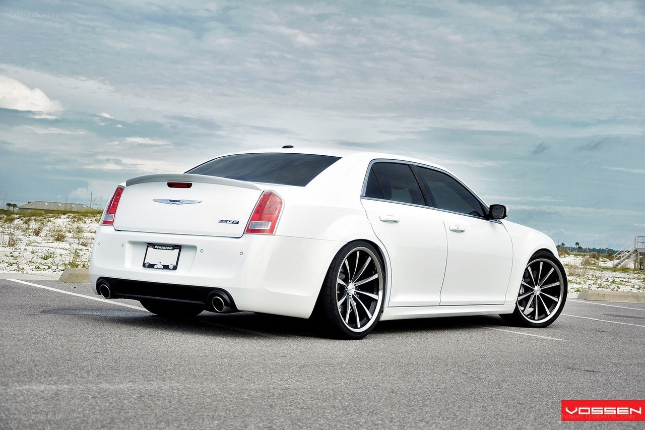 white chrysler 300 parked on beach