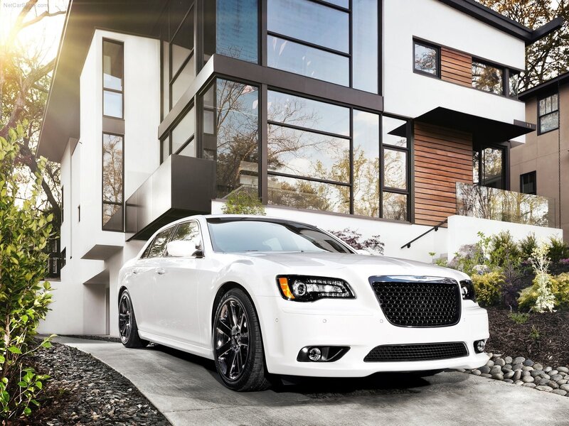 White Chrysler 300 parked outside modern home