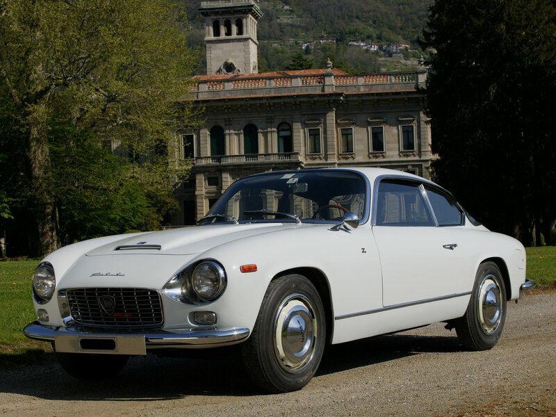 White classic car in front of mansion