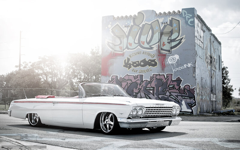 white classic car in graffiti alley