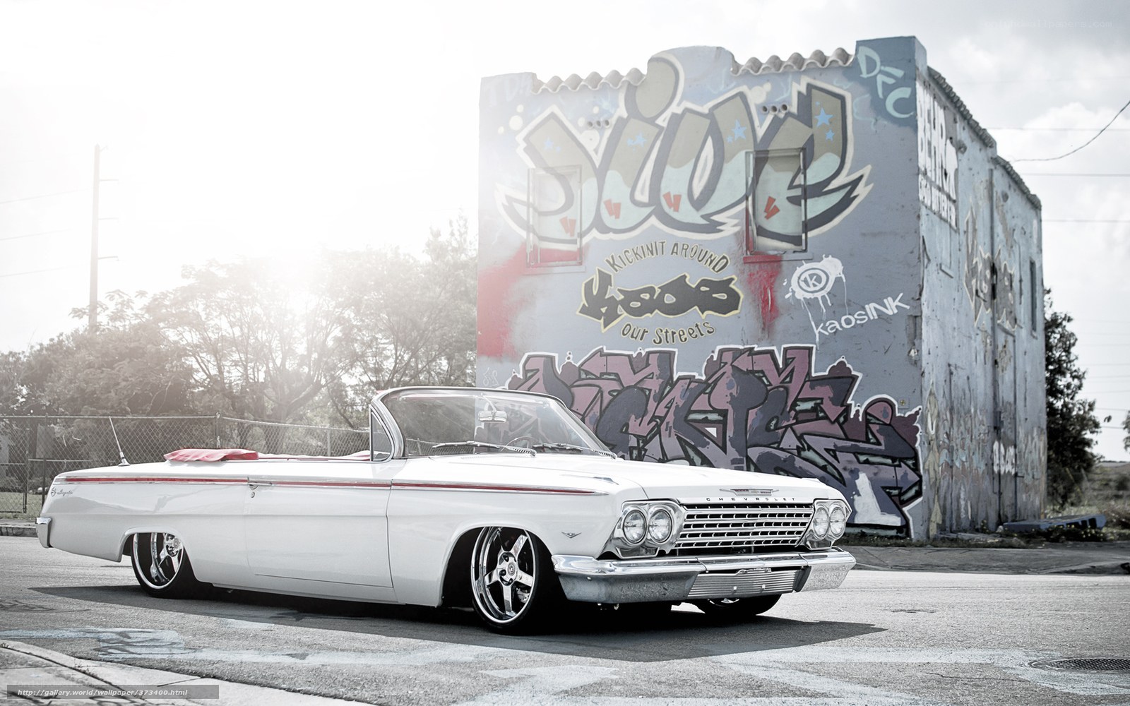 white classic car in graffiti alley