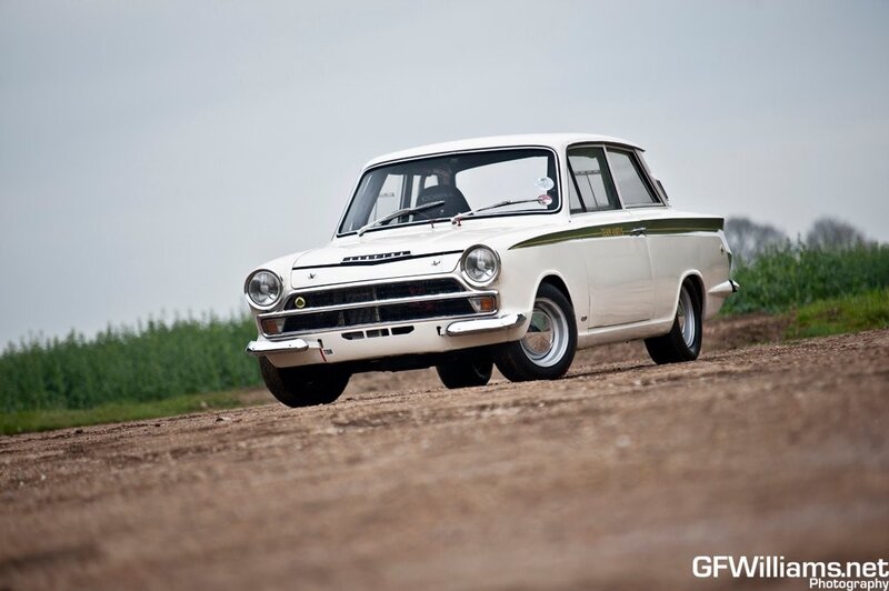 white classic car on dirt road