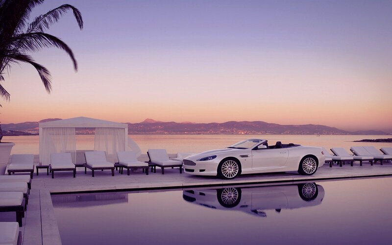 White convertible by pool at sunset