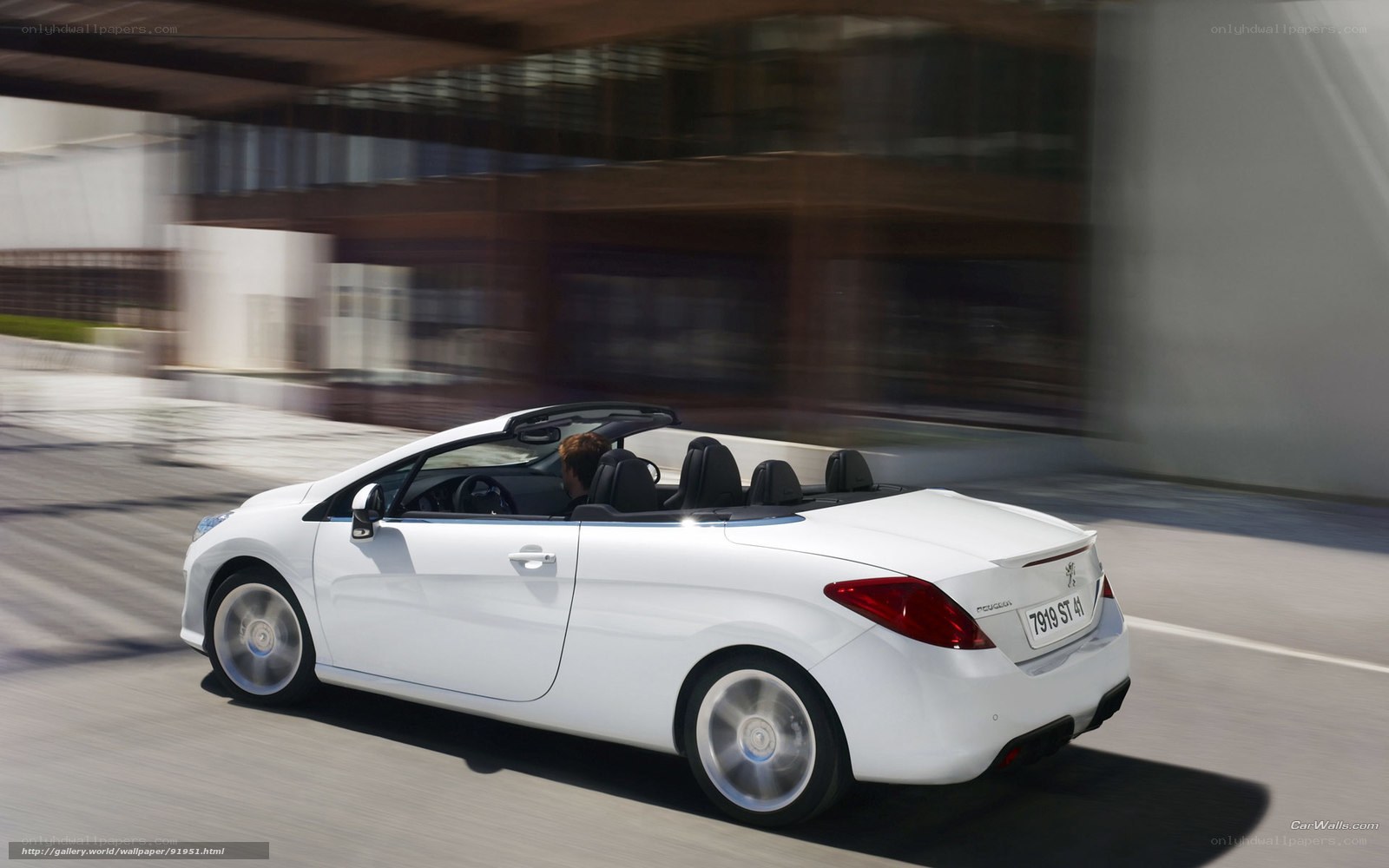 White convertible driving on city street