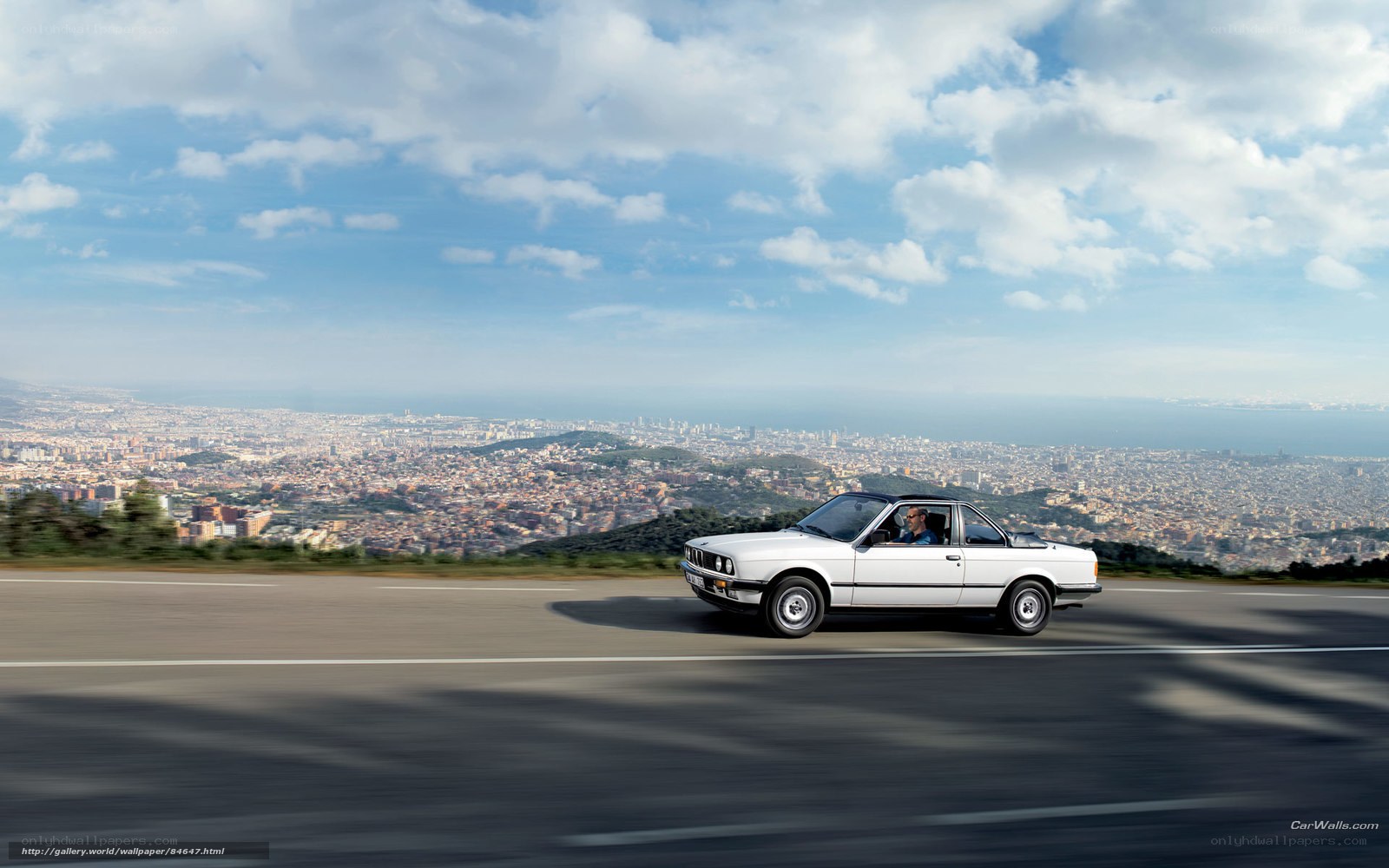 White convertible driving on coastal road