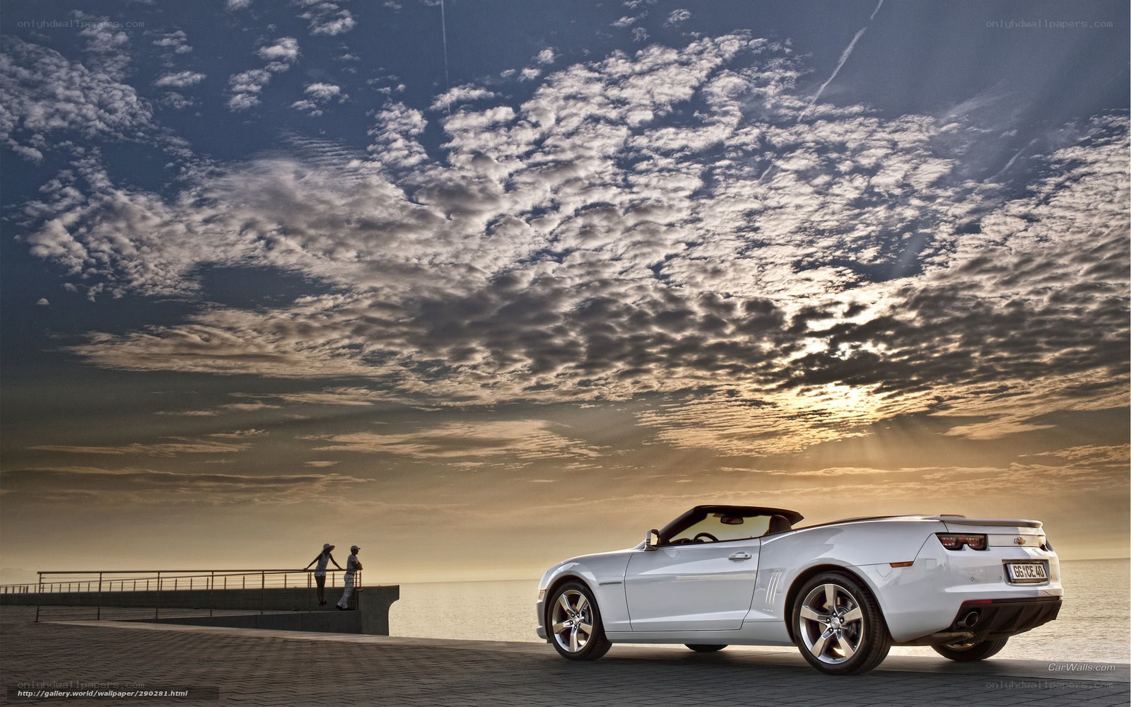 White convertible on a pier at sunset
