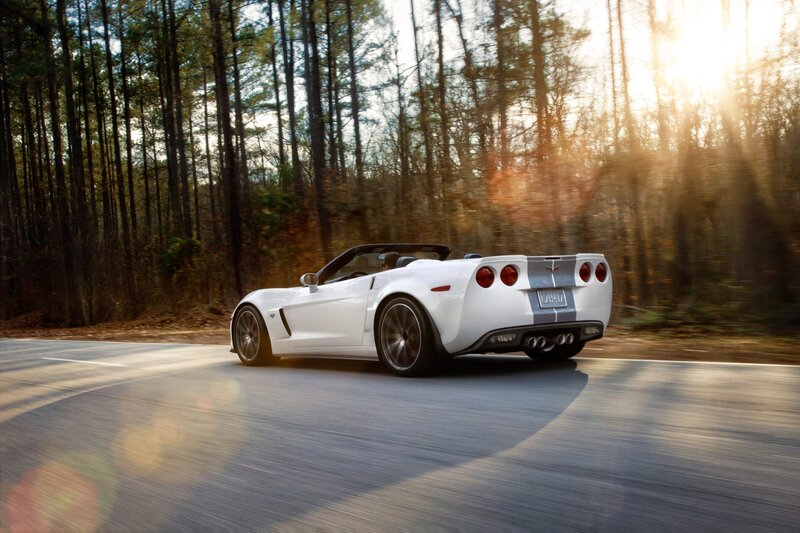 White Corvette convertible on forest road