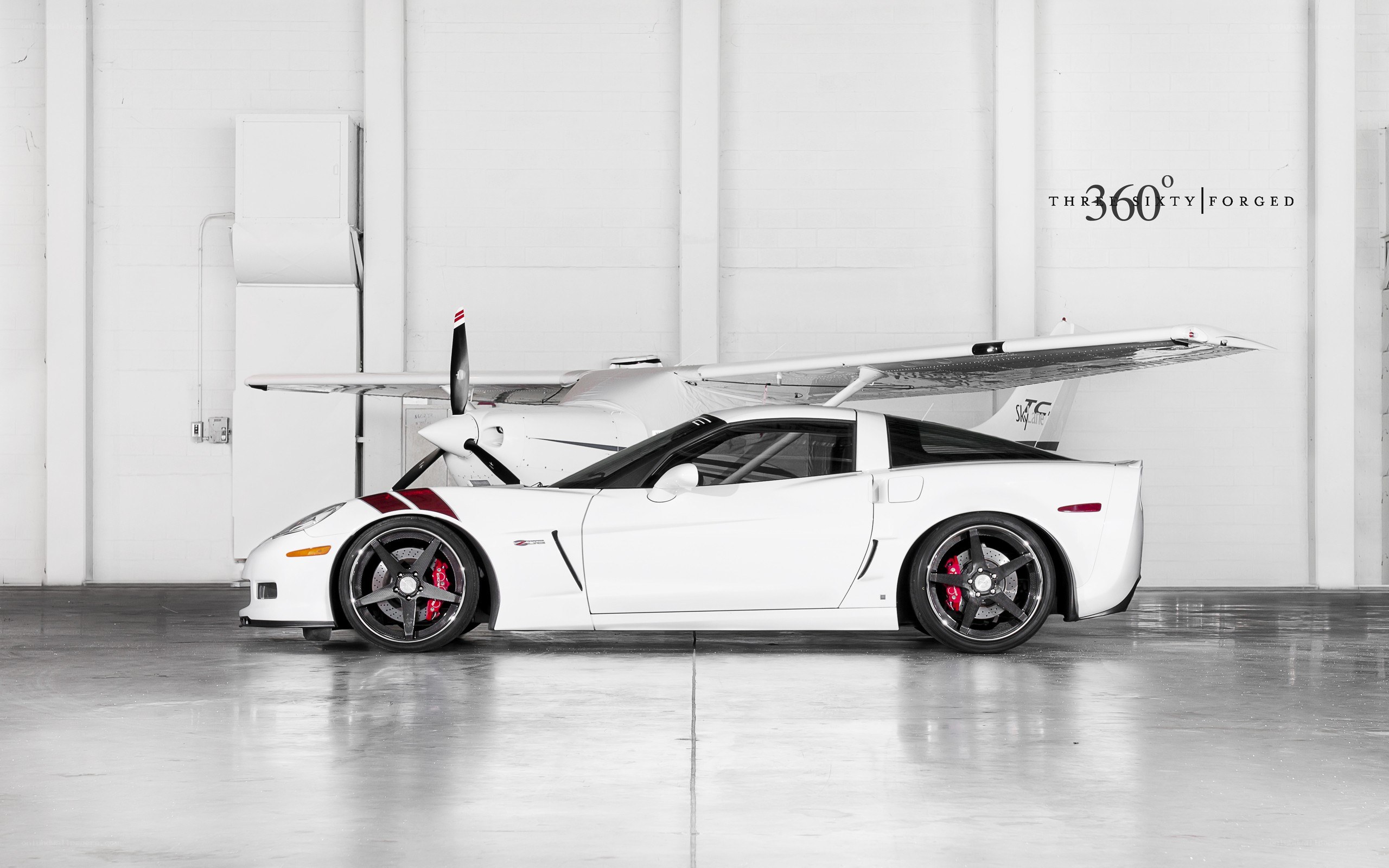 White Corvette with airplane in hangar