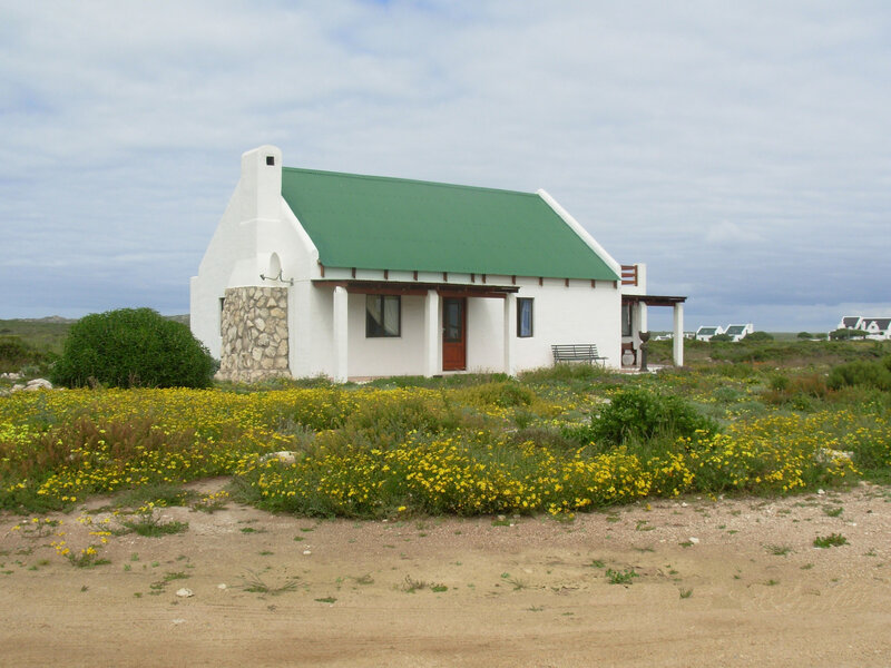 White cottage with green roof