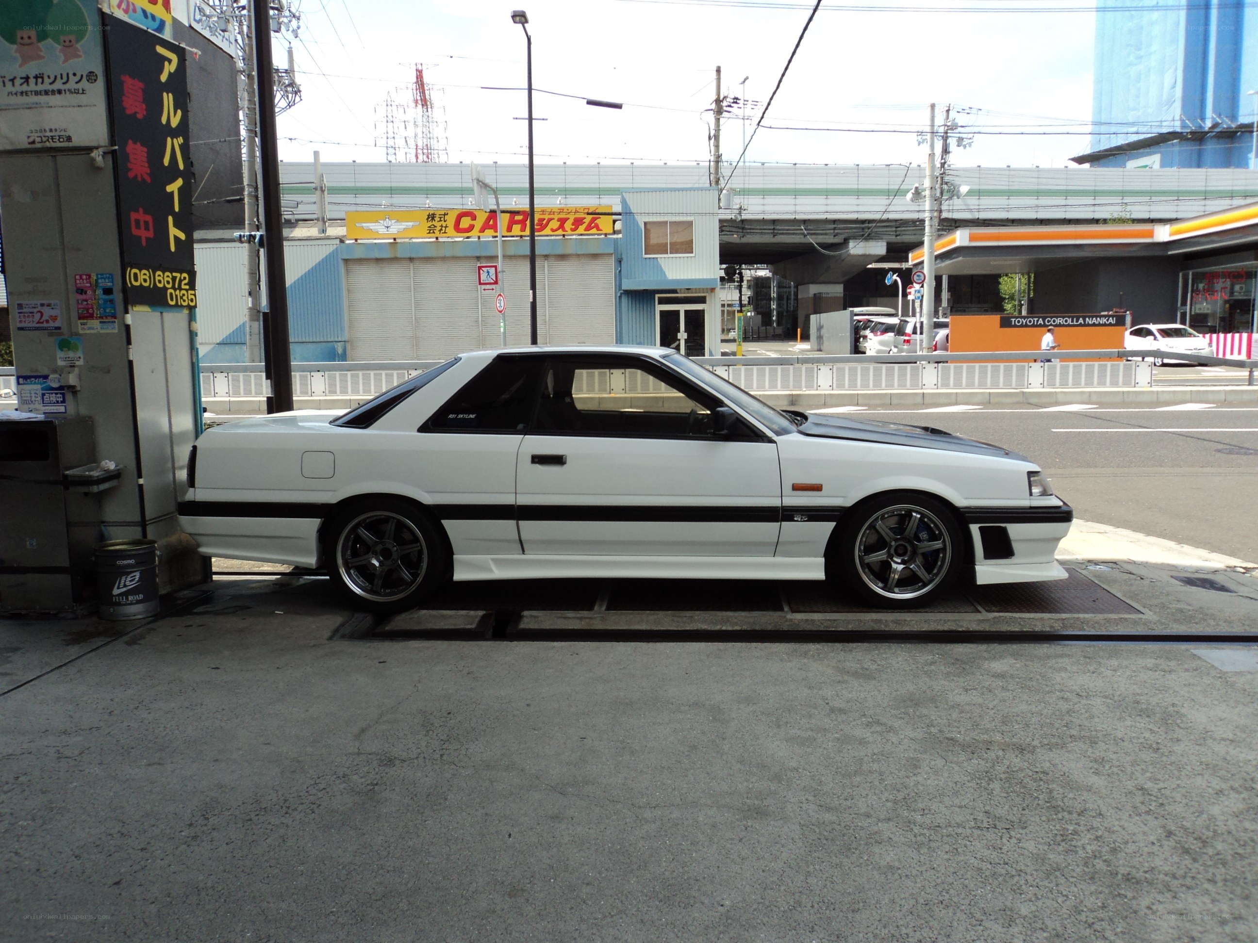 white coupe at gas station