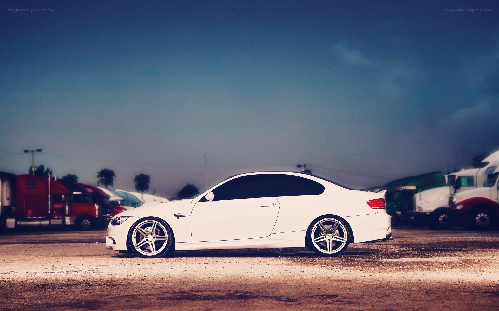 white coupe in truck yard