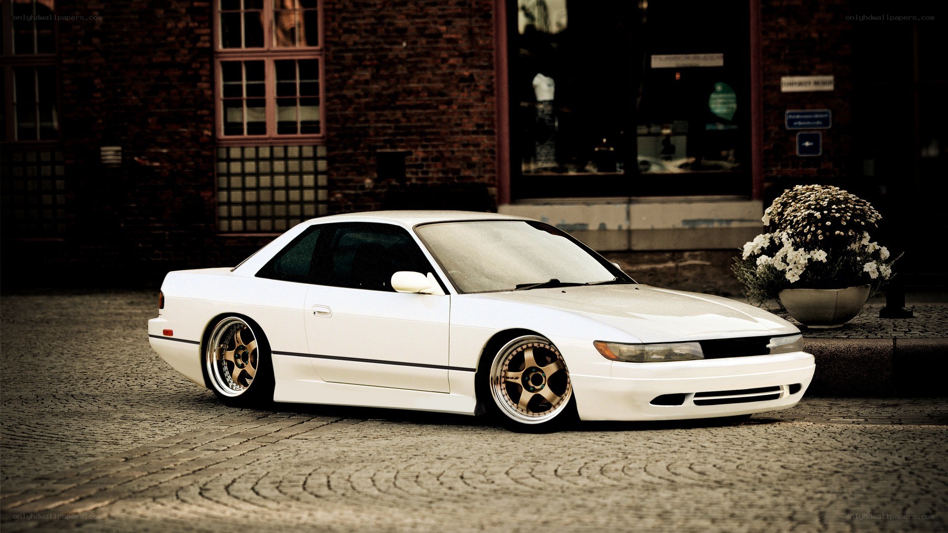 white coupe on cobblestones