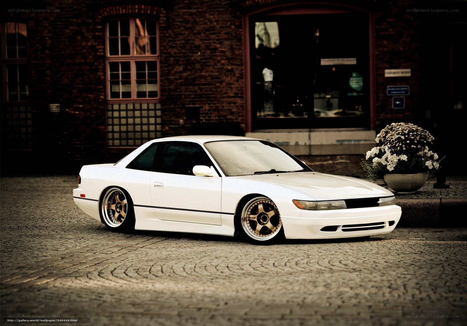 white coupe on cobblestones