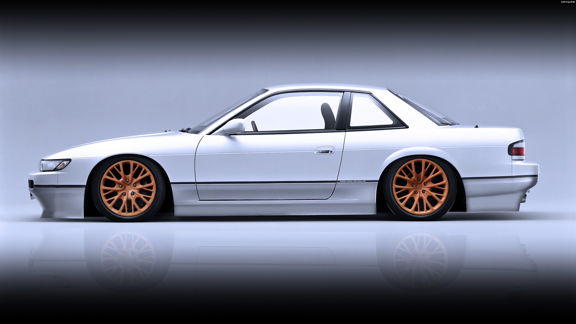 white coupe with orange wheels