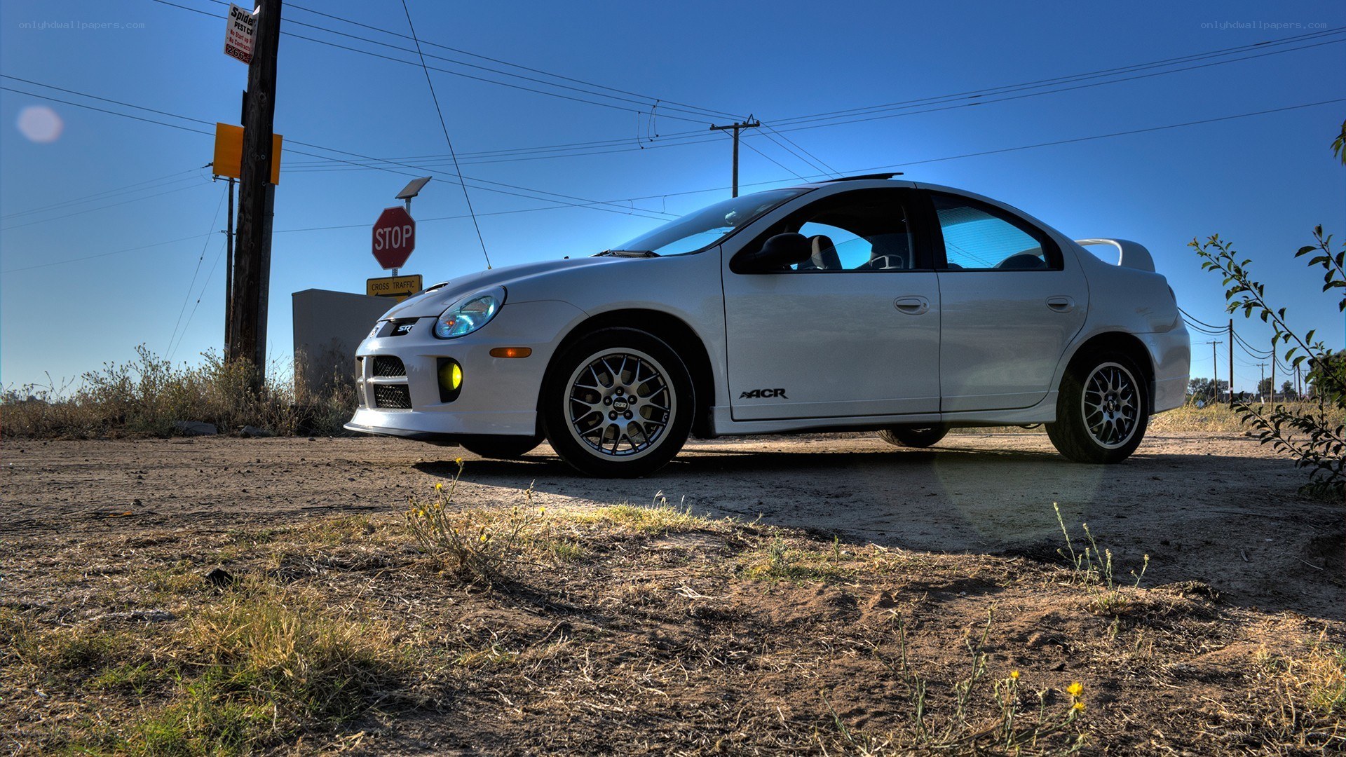 white dodge neon parked on dirt