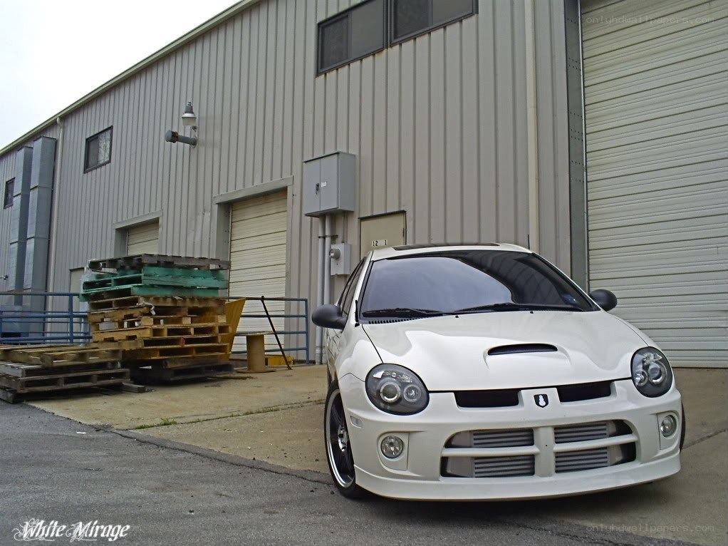 White Dodge Neon parked outside warehouse