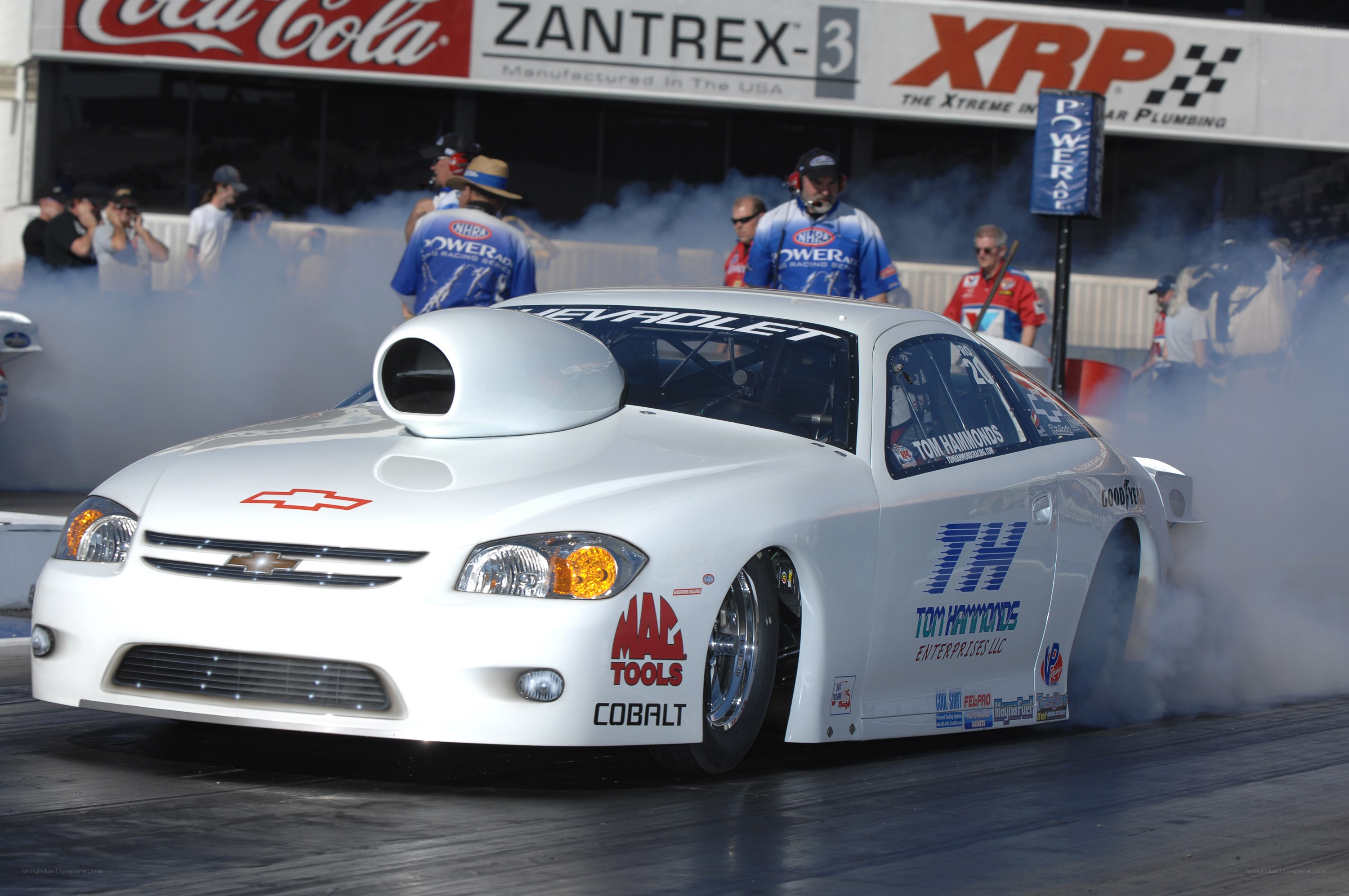 White drag racing car performing burnout