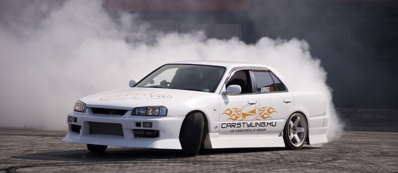 White drift car emitting smoke