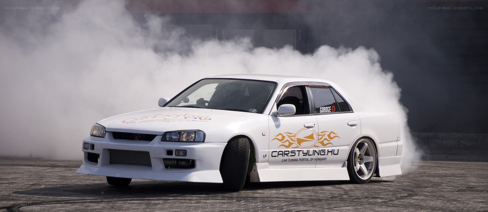 White drift car emitting smoke