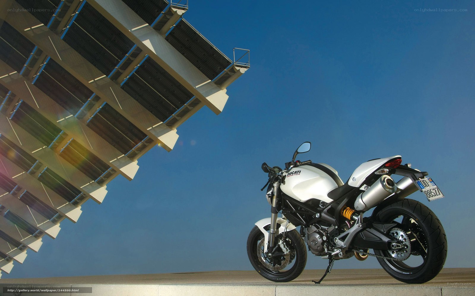 White Ducati motorcycle under solar panels
