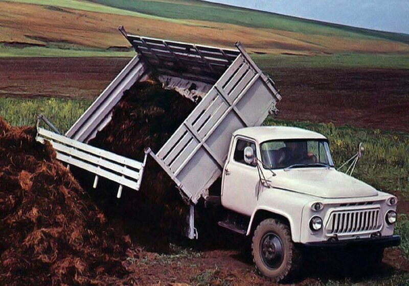 White dump truck unloading manure