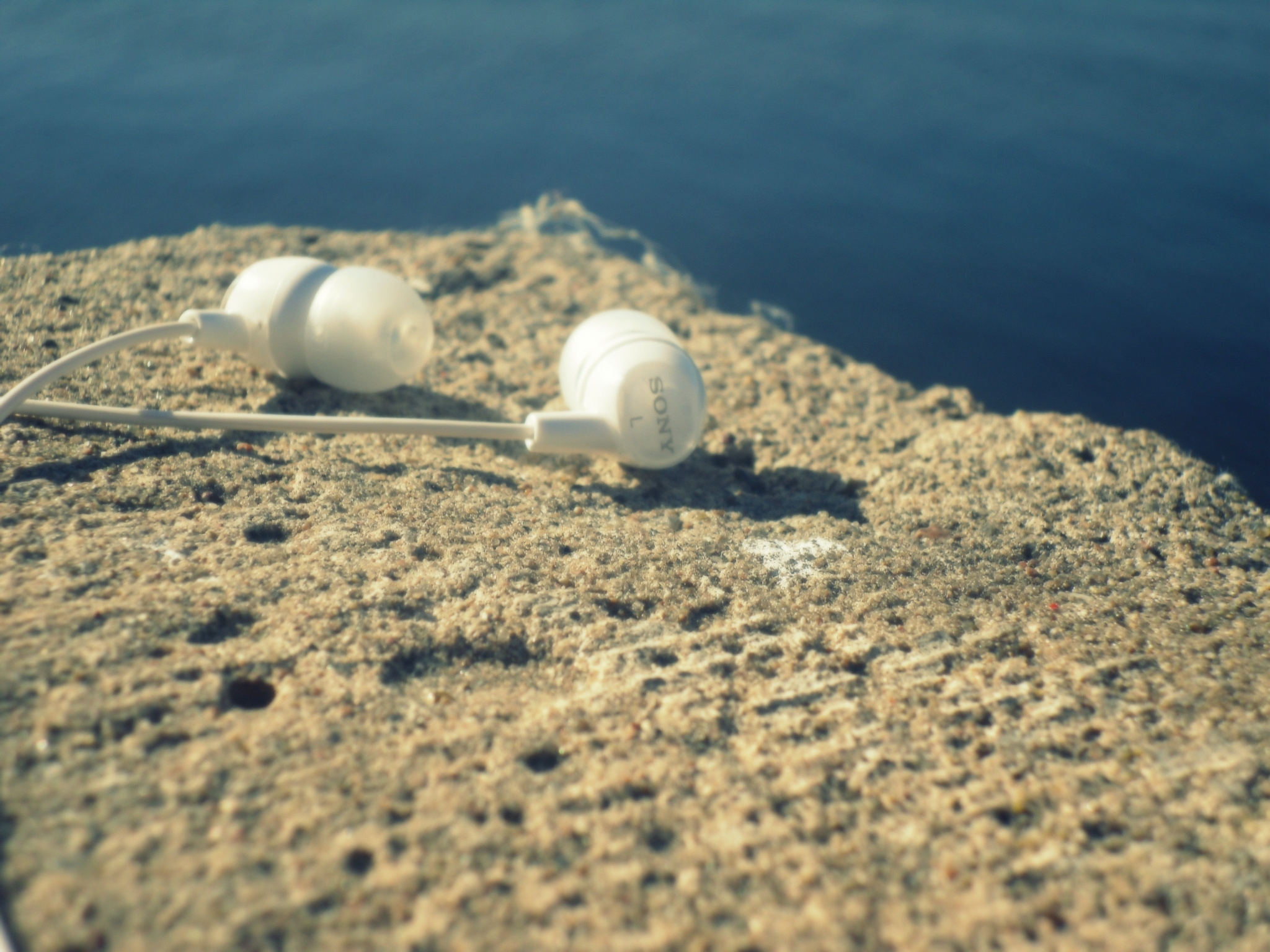 White earbuds on a rock