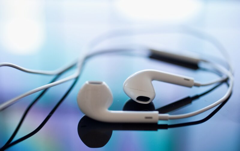 white earbuds on reflective surface