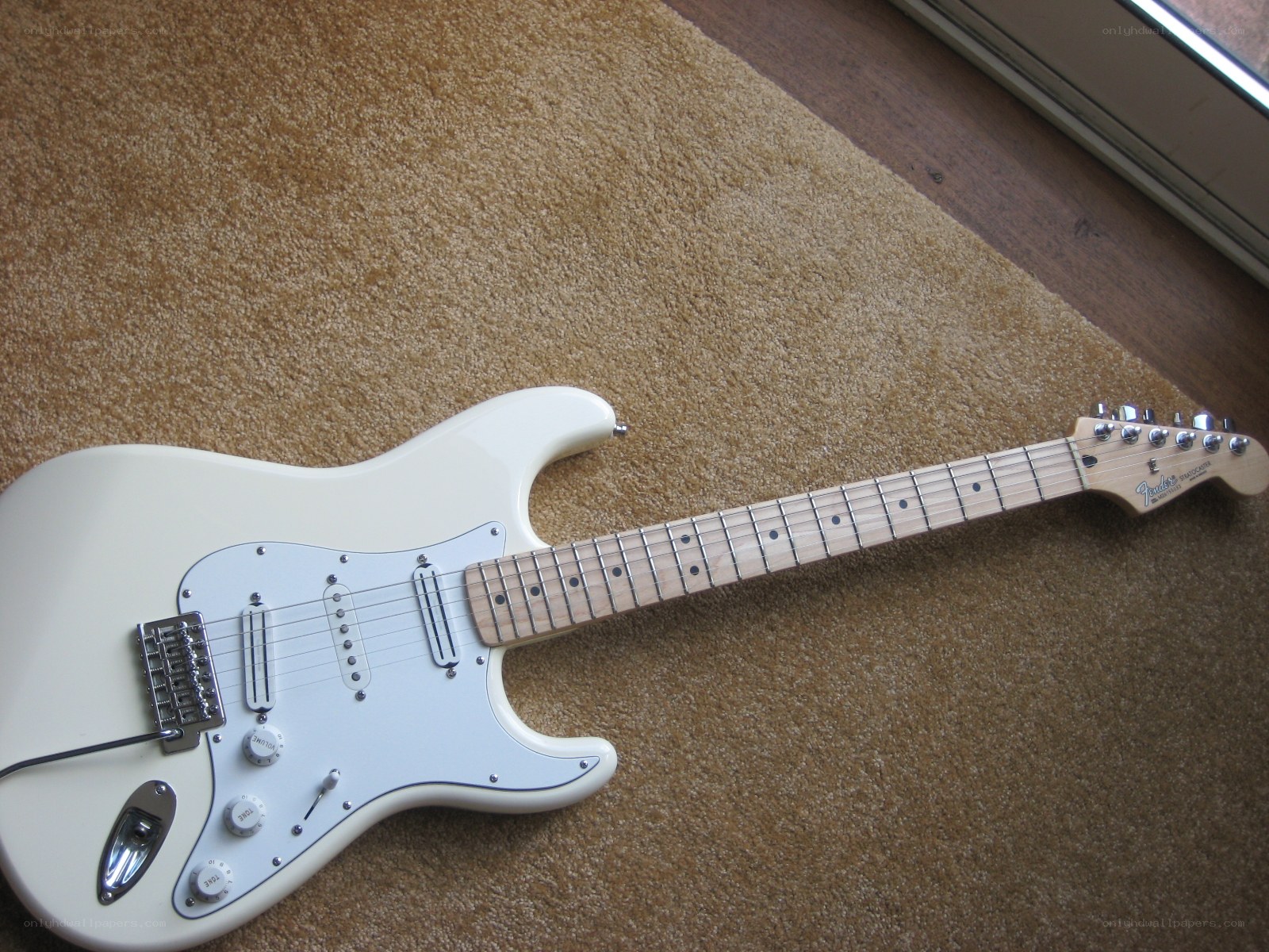 white electric guitar on carpet