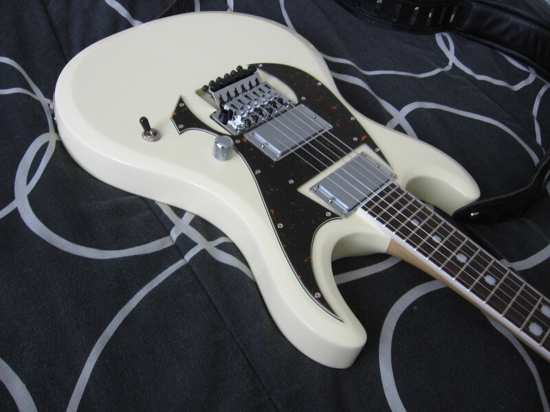 white electric guitar on patterned fabric