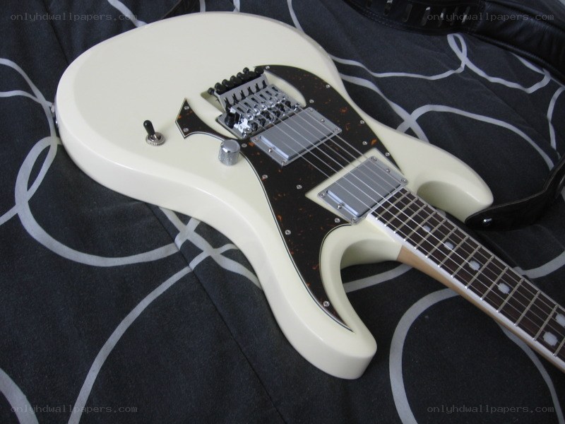 white electric guitar on patterned fabric