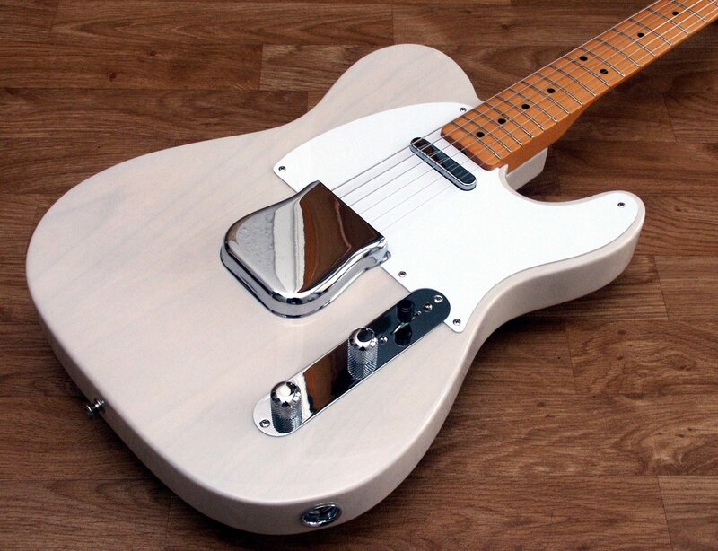 white electric guitar on wood floor