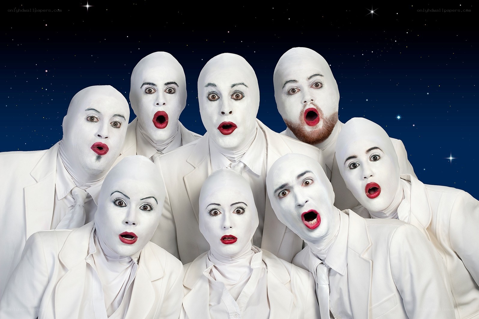 white-faced performers in suits