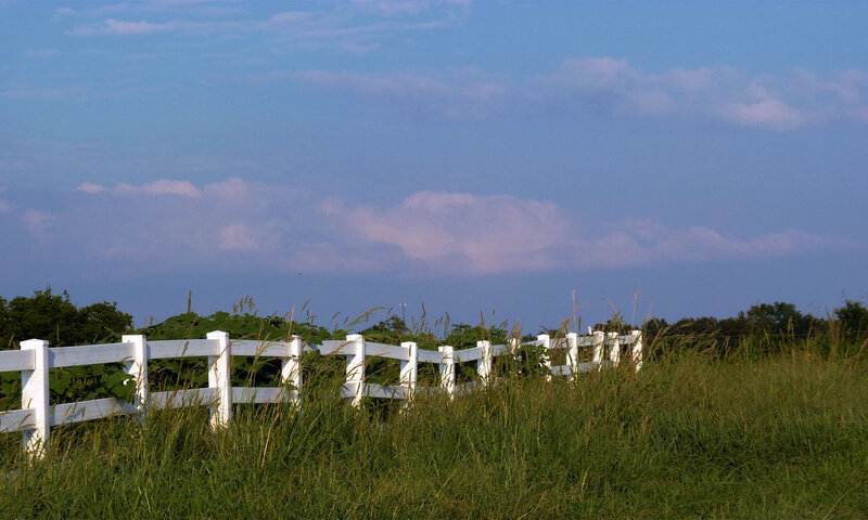 White fence in a grassy field