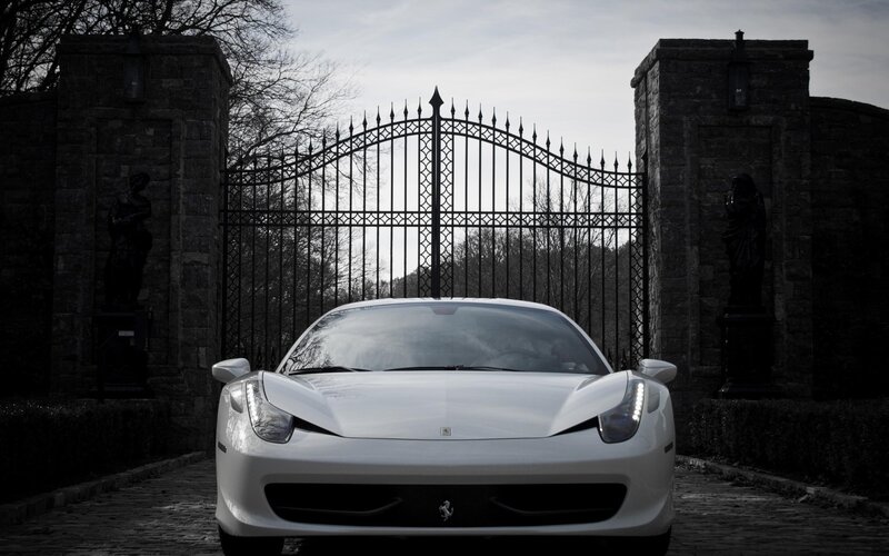 White Ferrari at a gated entrance