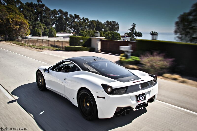 white ferrari driving on coastal road