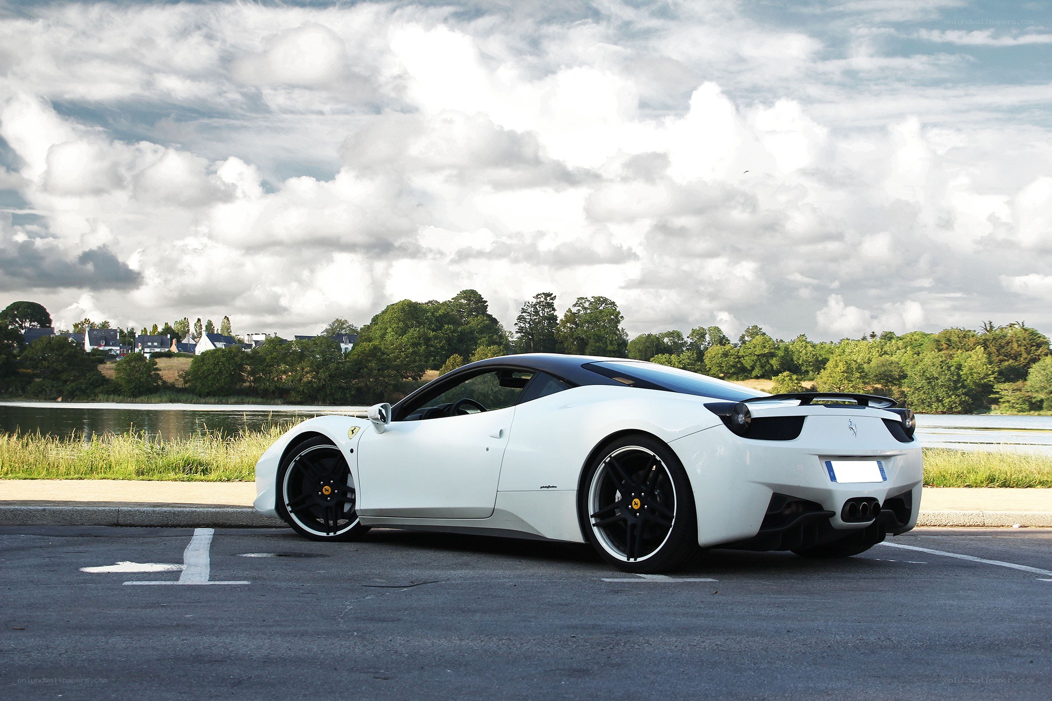 White Ferrari parked by a lake